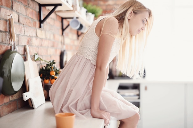 Woman with dress sit on kitchen