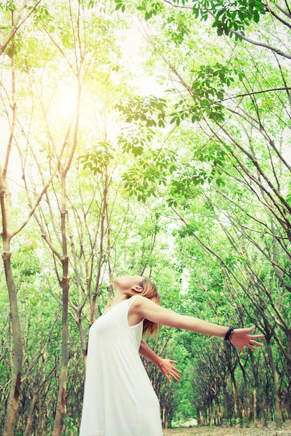 Free photo woman with dress stretching her arms in the forest