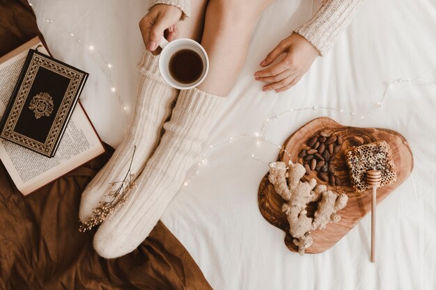 Woman with drink near healthy snacks and book