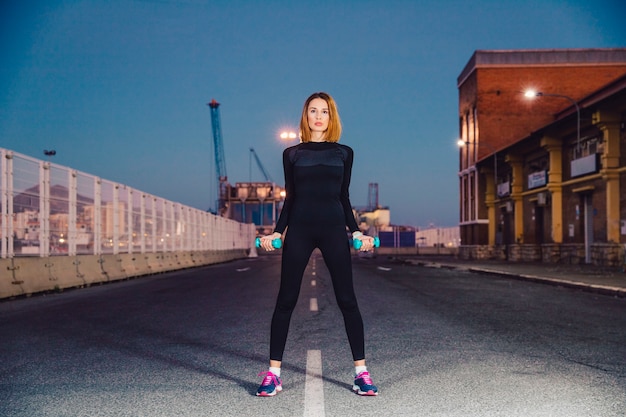 Free photo woman with dumbbells on road