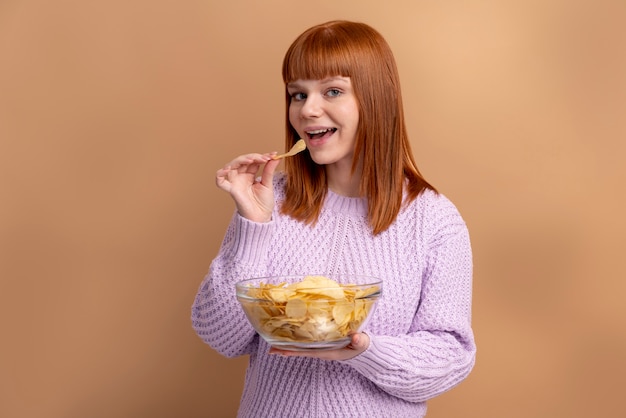 Free photo woman with eating disorder eating chips