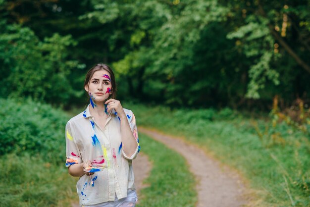 Woman with face and clothes stained paint with pensive face