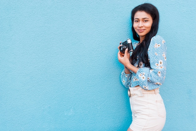 Free photo woman with floral blouse holding a camera