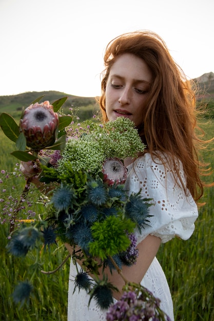 Free photo woman with flowers bouquet side view