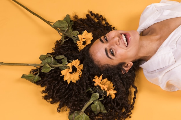 Free photo woman with flowers on hair lying on floor