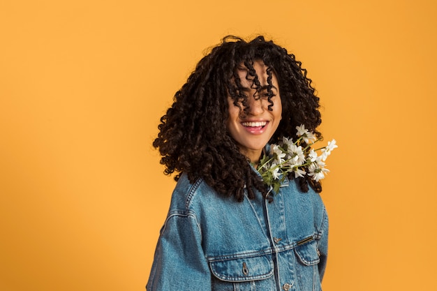 Free photo woman with flowers under jacket looking at camera