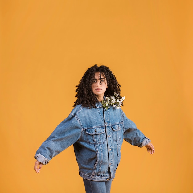 Woman with flowers under jacket spreading hands