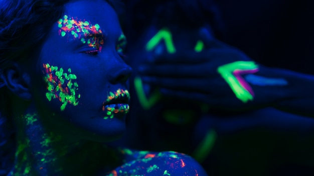 Free photo woman with fluorescent make-up on face and hand