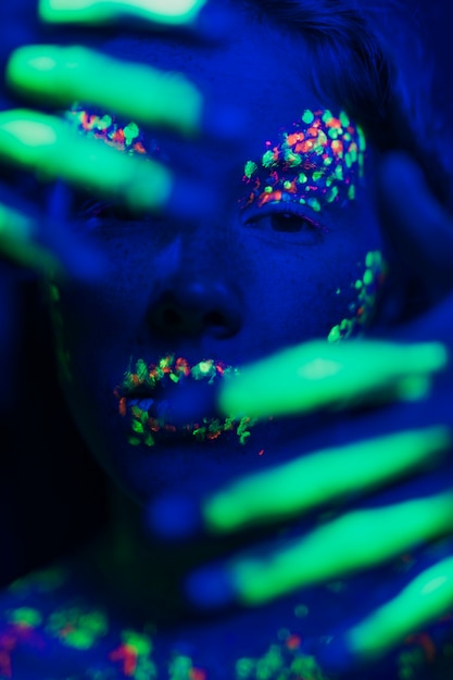 Free photo woman with fluorescent make-up on face and hands