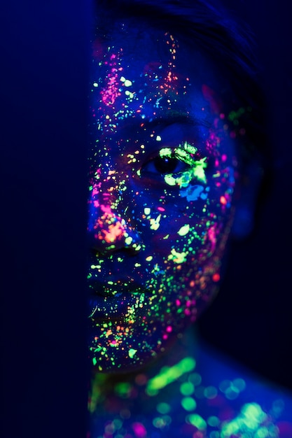 Free Photo woman with fluorescent make-up on half face