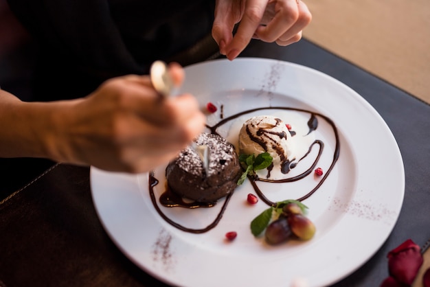 Free photo woman with fork and delicious fresh chocolate dessert in restaurant