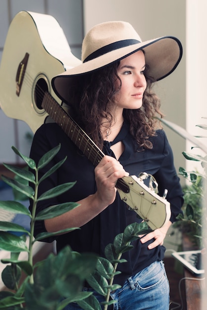 Free photo woman with guitar guitar on her shoulder