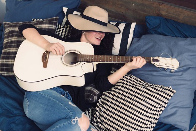 Woman with guitar and hat