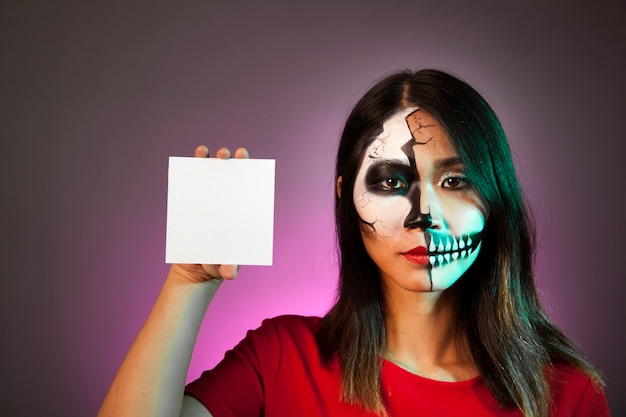 Woman with halloween mask showing card