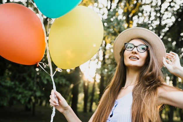 Woman with hat and balloons in park