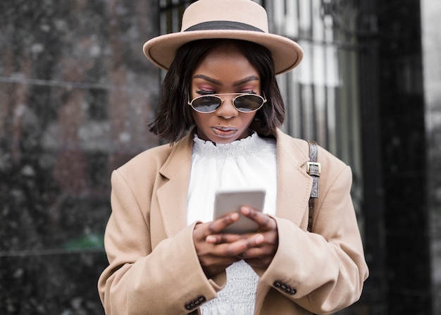 Woman with hat looking on her phone