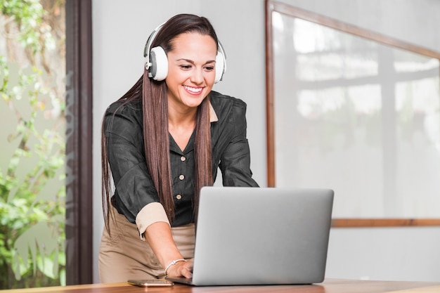 Woman with headphones checking her laptop