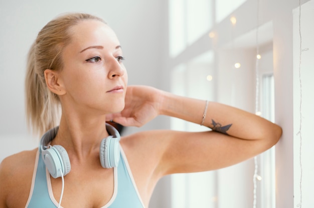 Free Photo woman with headphones looking out on window