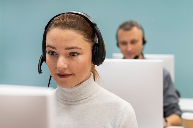 Free photo woman with headphones working in a call center office