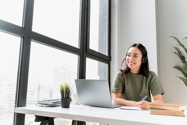 Woman with headset having video call on laptop