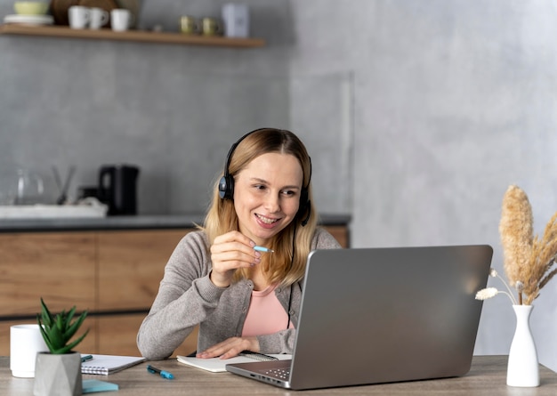 Free photo woman with headset working on laptop