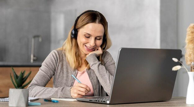 Woman with headset working on laptop