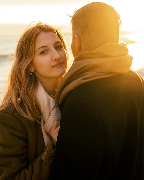 Free photo woman with her boyfriend by the beach in winter