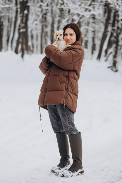 Woman with her cute little dog in a winter park