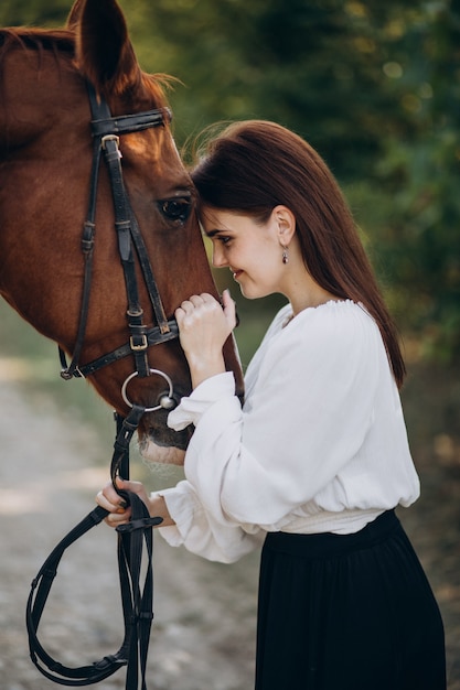 Woman with horse in forest