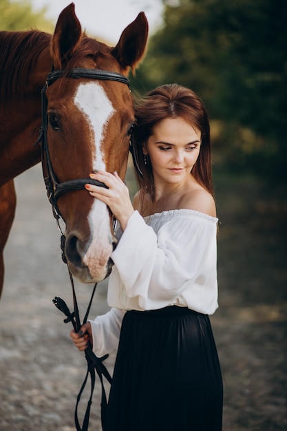 Woman with horse in forest