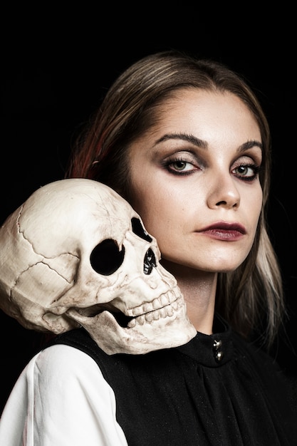 Woman with human skull on shoulder