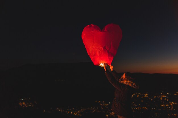 Woman with a kite of hot air at night