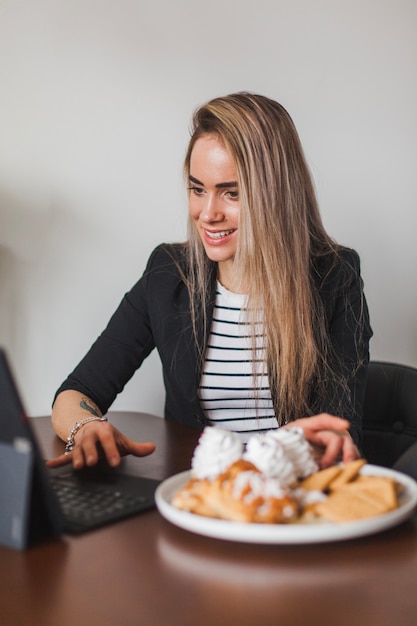 Woman with laptop and pastry