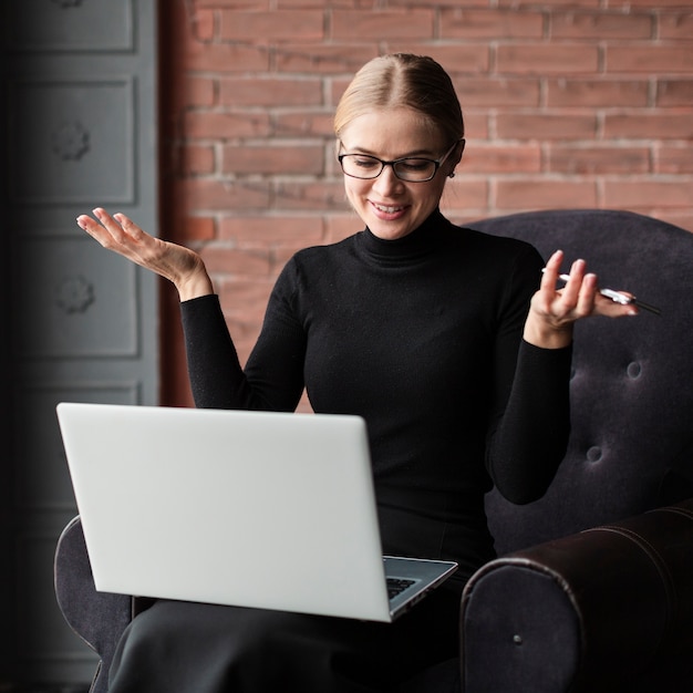 Free photo woman with laptop and phone on couch