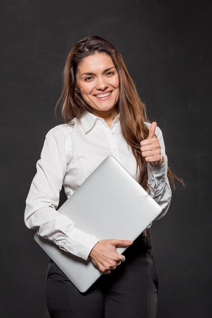 Woman with laptop showing ok sign