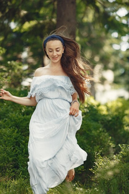 Woman with long hair. Lady in a blue dress. Girl with untouched nature.