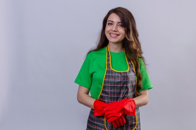 woman with long wavy hair wearing apron and rubber gloves smiling with happy face standing