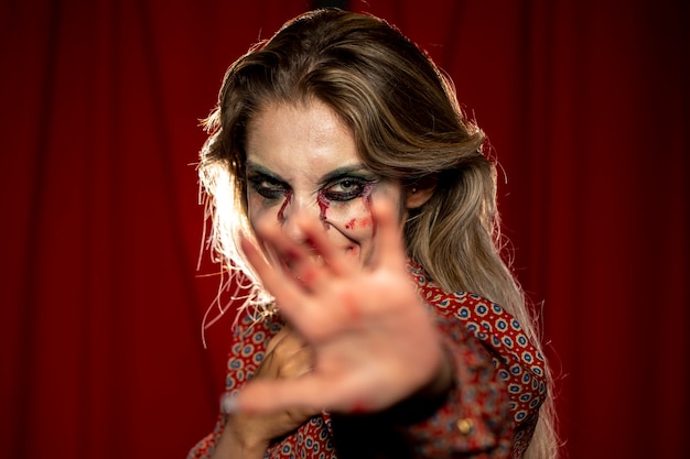 Woman with make-up as blood and hand in front of her