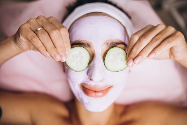 Free Photo woman with mask and cucumber on her eyes