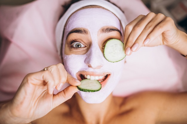 Free Photo woman with mask and cucumber on her eyes