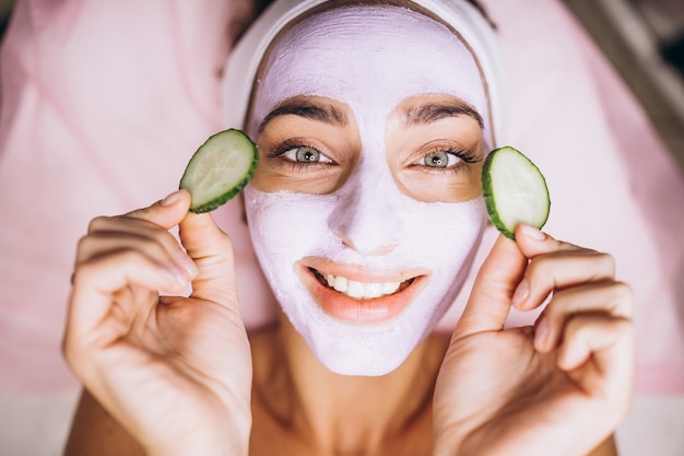 Free photo woman with mask and cucumber on her eyes