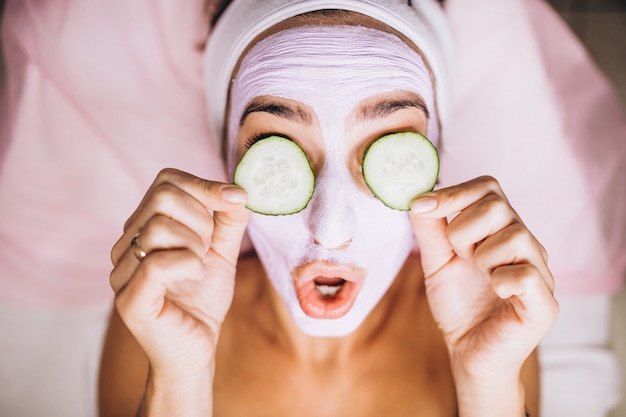 Free Photo woman with mask and cucumber on her eyes