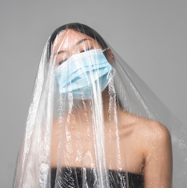 Woman with medical mask being covered in plastic