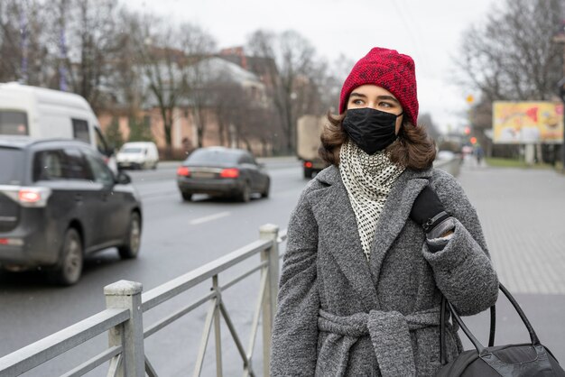 Woman with medical mask outdoors in the city