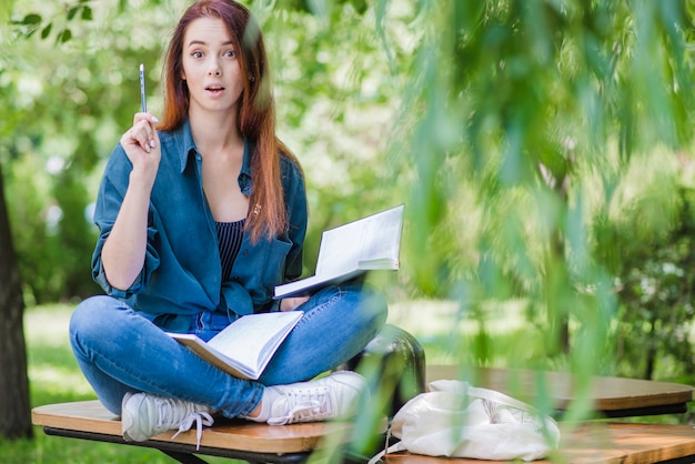 Free photo woman with notebooks in park