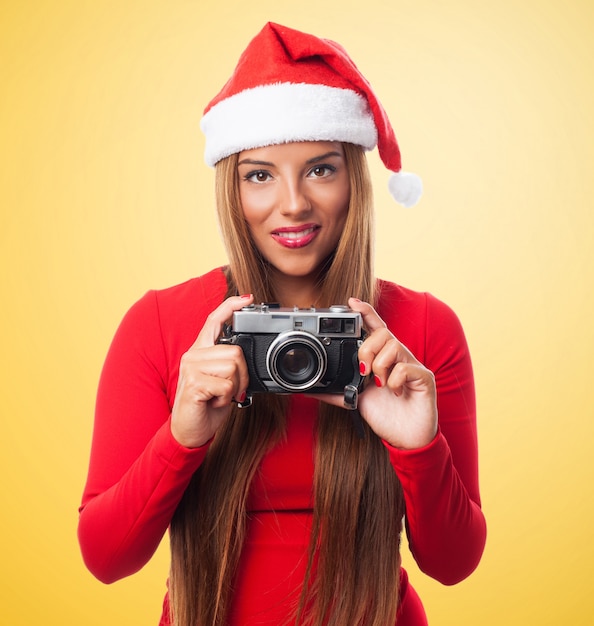 Woman with an old camera in a yellow background