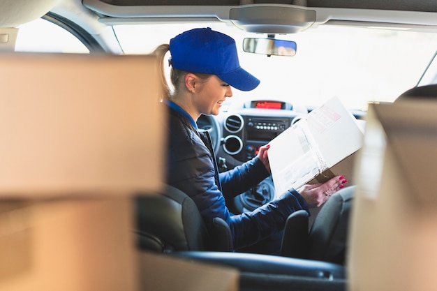 Free Photo woman with packed box in car