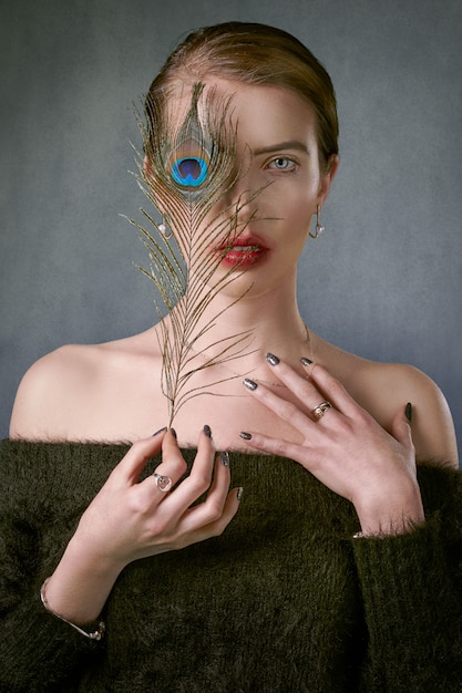 Free photo woman with a peacock feather in the eye