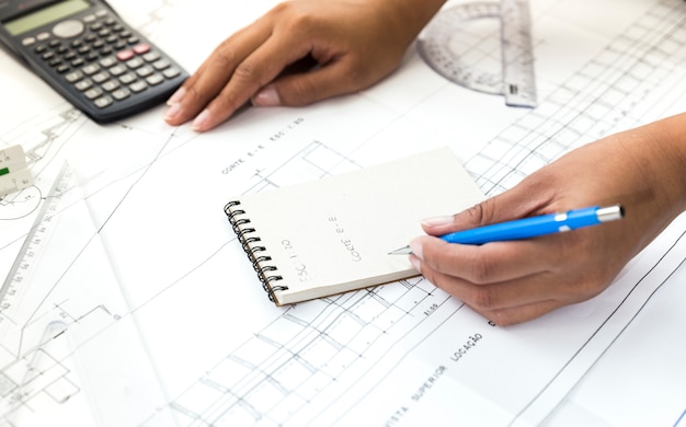 Free Photo woman with pen taking notes near plan