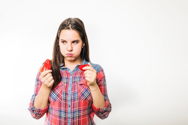 Woman with peppers puffing cheeks